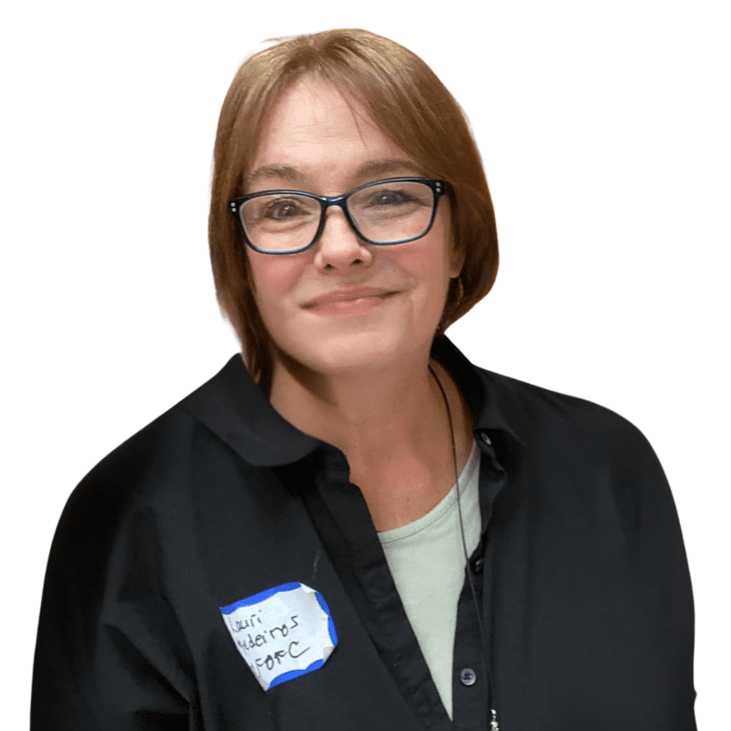 white woman with short light brown hair and glasses wearing a black collared shirt with a lighter shirt beneath